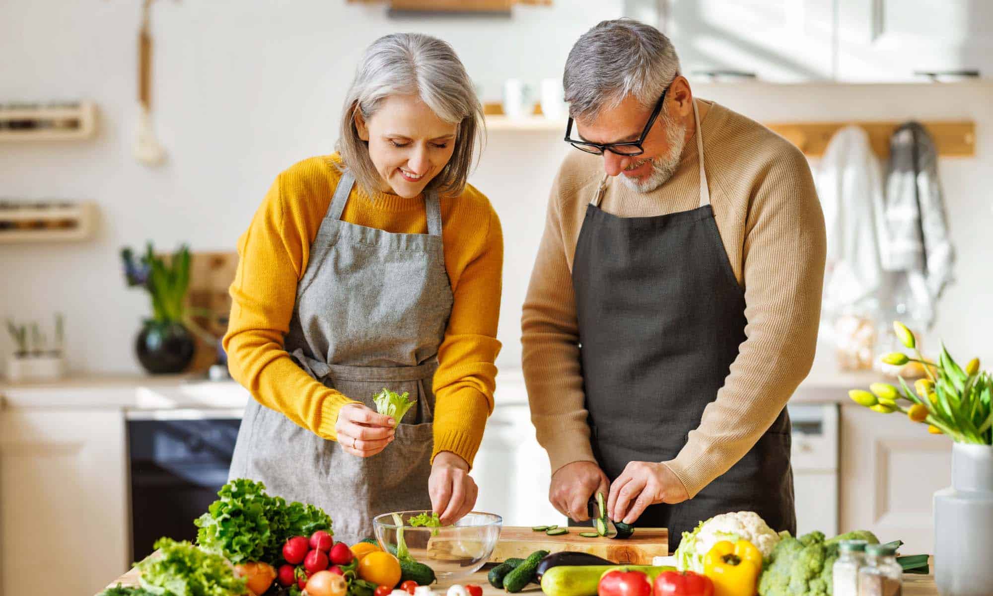 healthy mature couple preparing a mediterranean diet recipe.